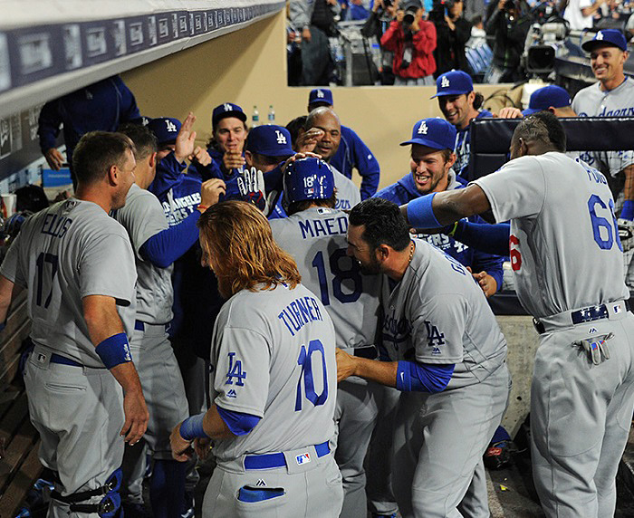 After first receiving the traditional silent treatment for hitting his first major league home run, Dodgers pitcher Kenta Maeda is swarmed by his teammates. (Photo credit - Jon SooHoo)