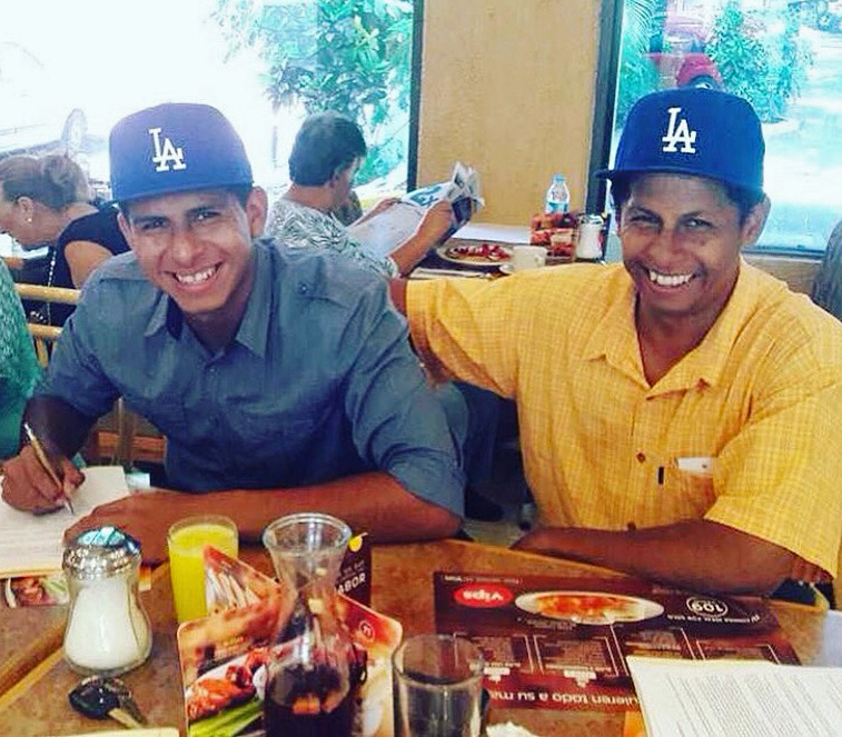 Ricky Hernandez (left) signs his first professional contract with the Dodgers as his father, Abel, looks on. (Photo courtesy of @intelligentbase)